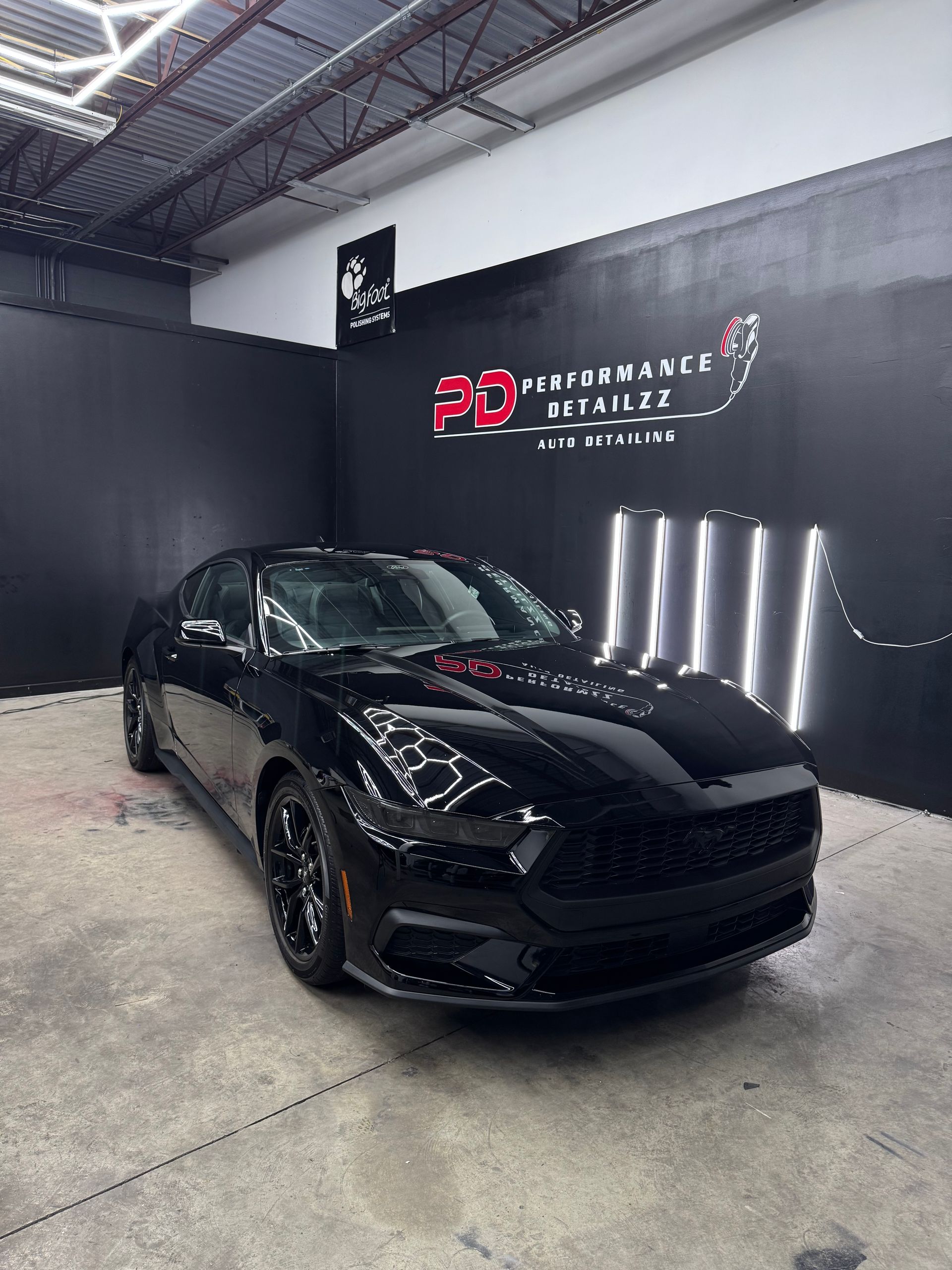 Black Dodge Charger in a garage with SQ Performance logo.