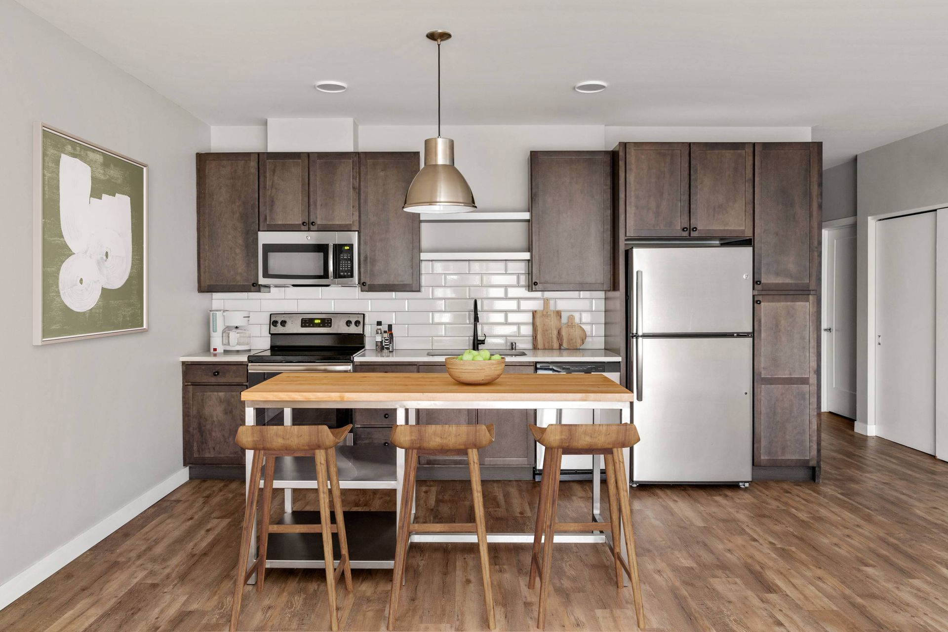 A kitchen with stainless steel appliances and wooden cabinets.