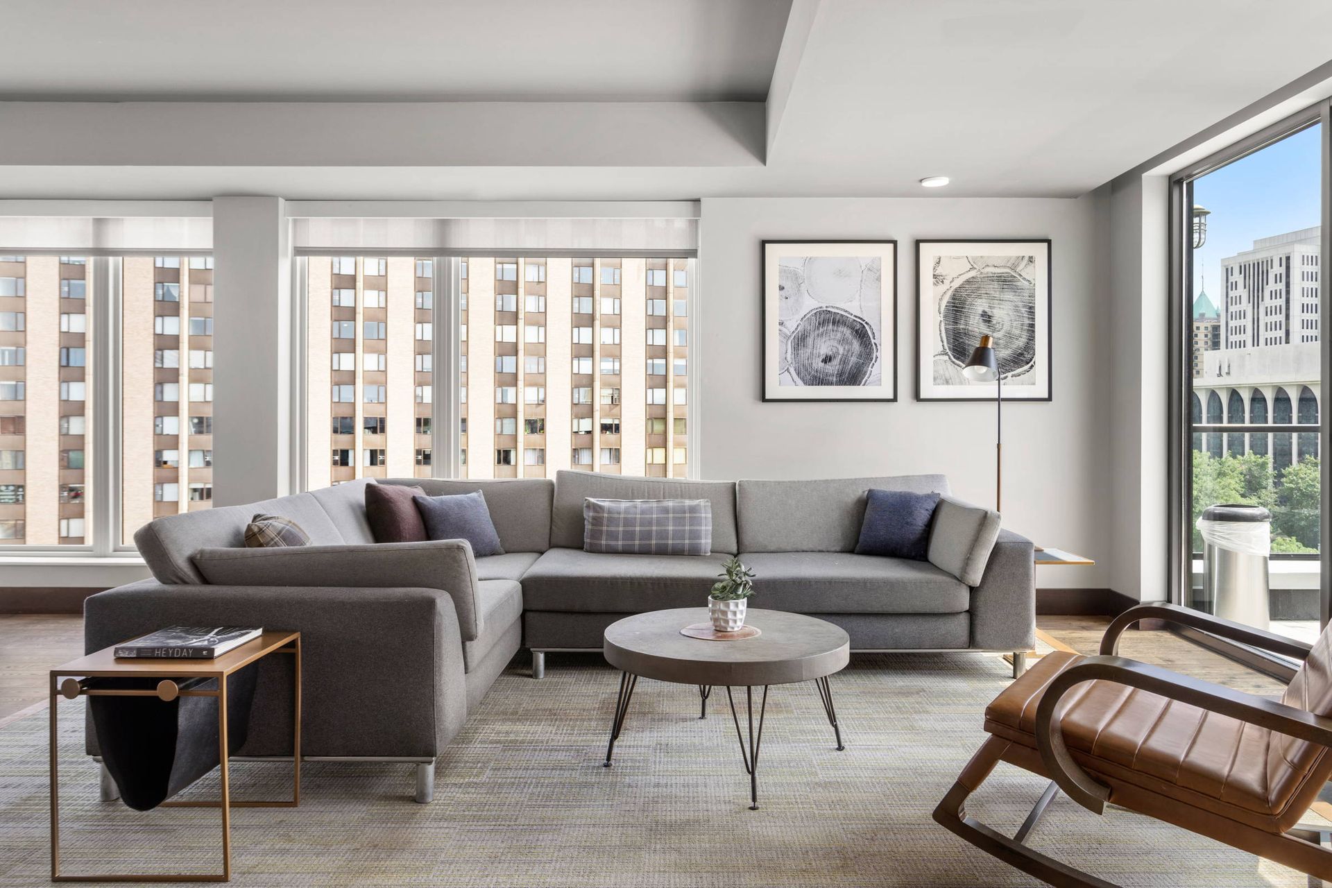 A living room with a couch , chair , table and large windows.