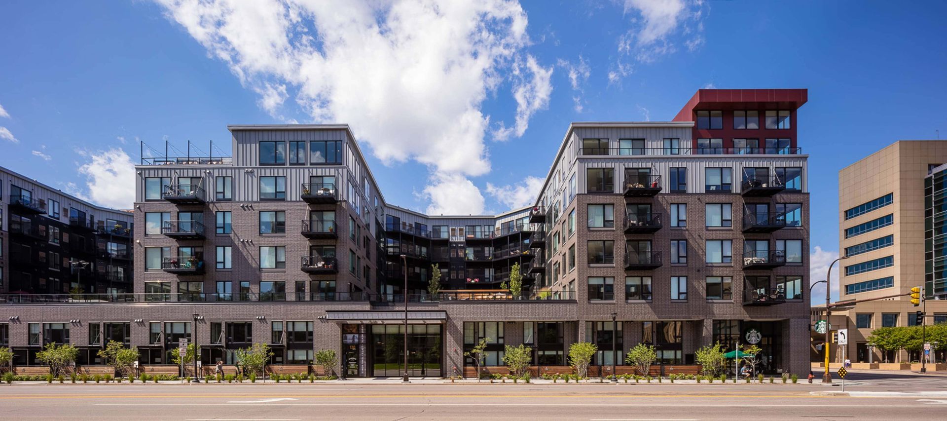 A large apartment building with a lot of windows on a sunny day.