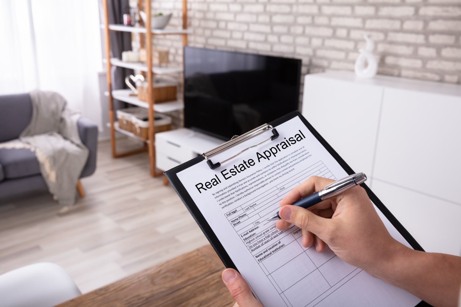 Male real estate agent working on an appraisal form with a clipboard.