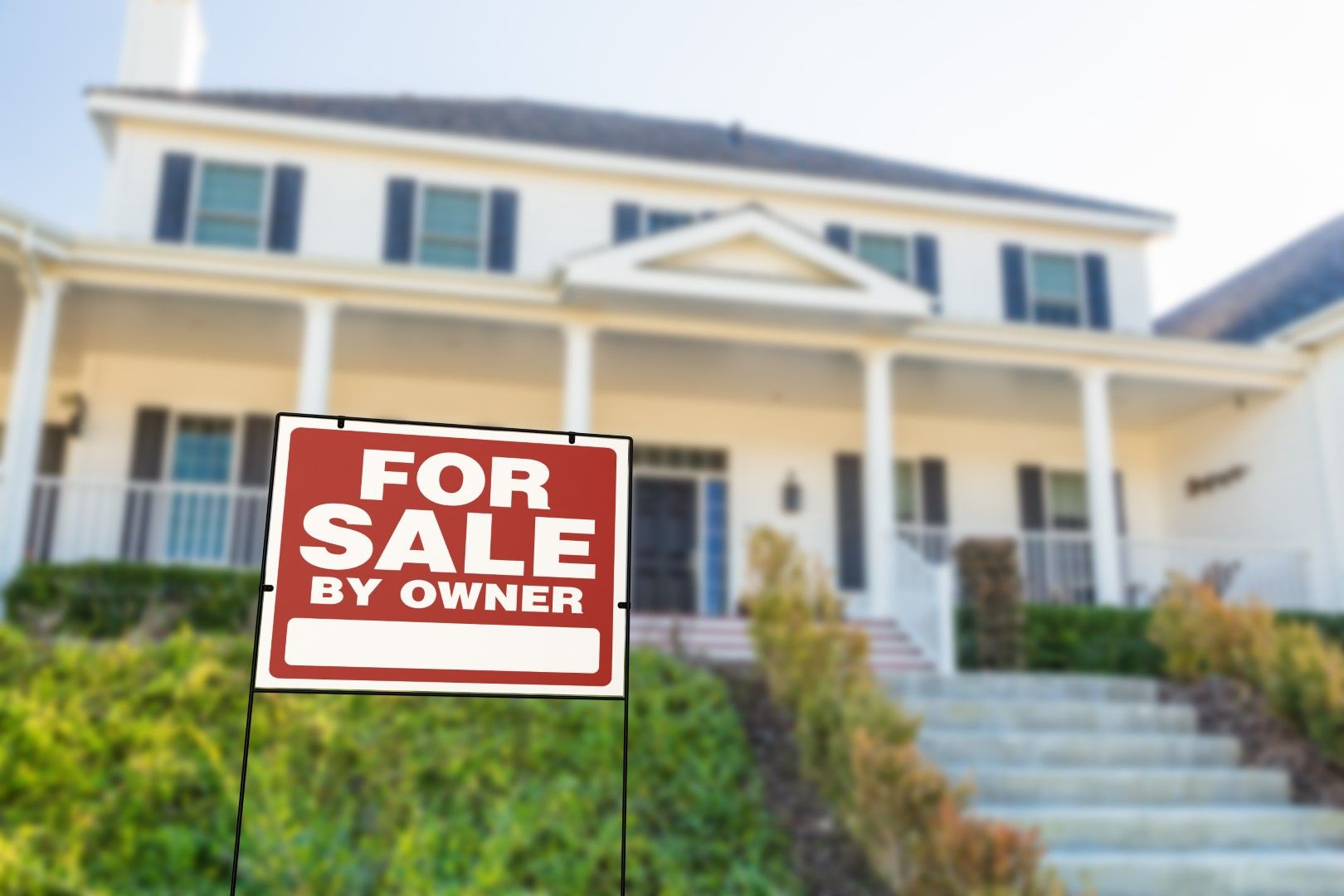 House with a For Sale By Owner sign, signaling a private sale