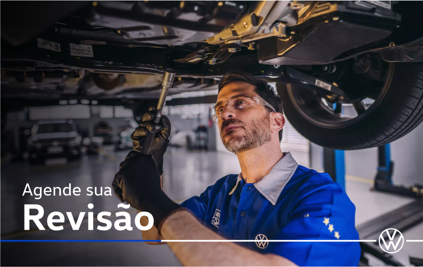 Um homem de camisa azul está trabalhando embaixo de um carro.
