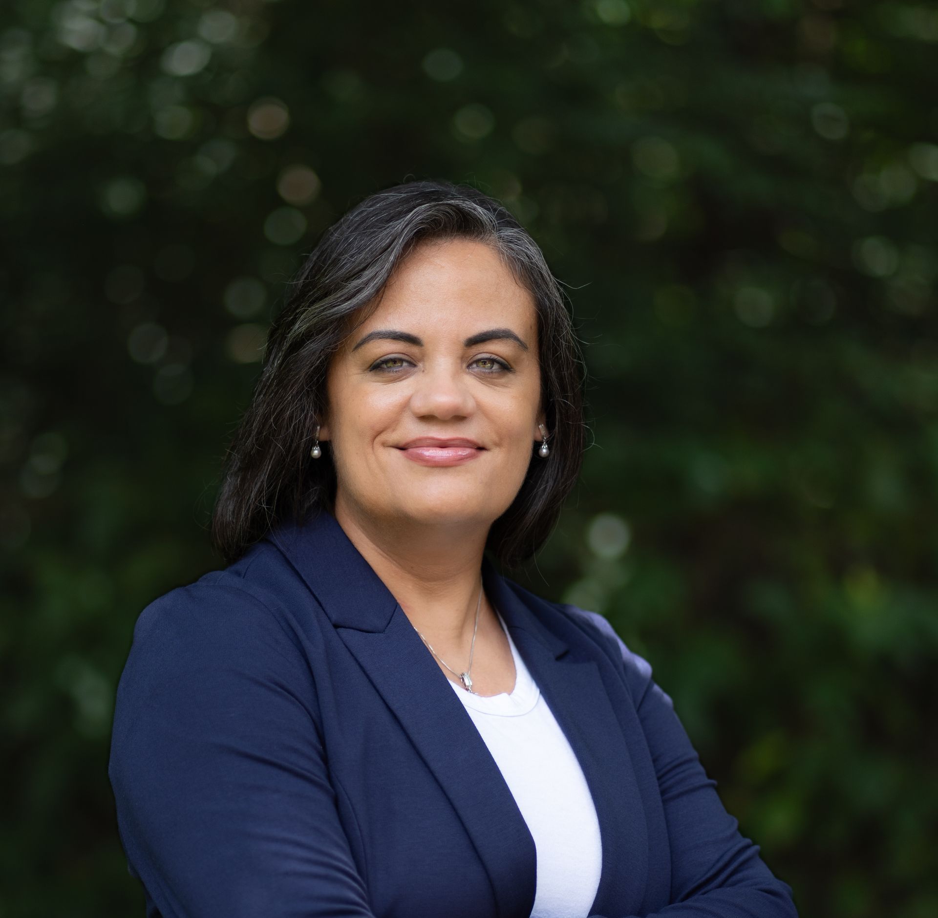Vanessa's headshot with a background of green foliage