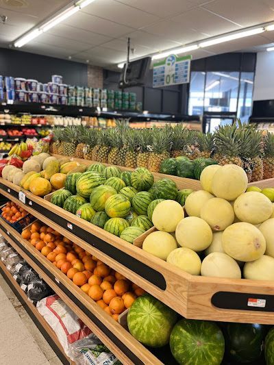 A grocery store aisle filled with lots of fruits and vegetables.