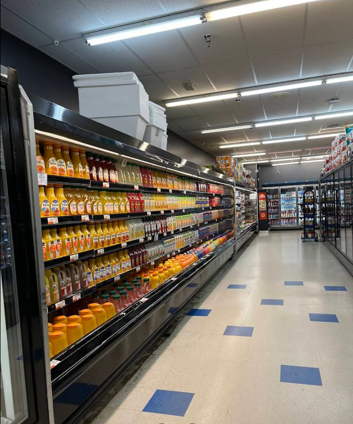 A long aisle of a grocery store filled with lots of products