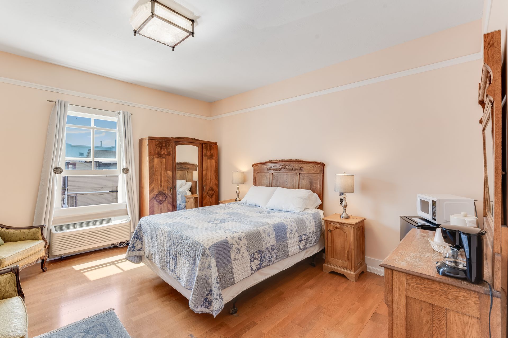 Bedroom with a bed, wooden furniture, and window with natural light.