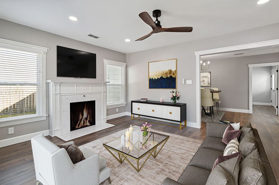 Living room with fireplace, TV, neutral walls, modern furniture, rug, and wood floors.