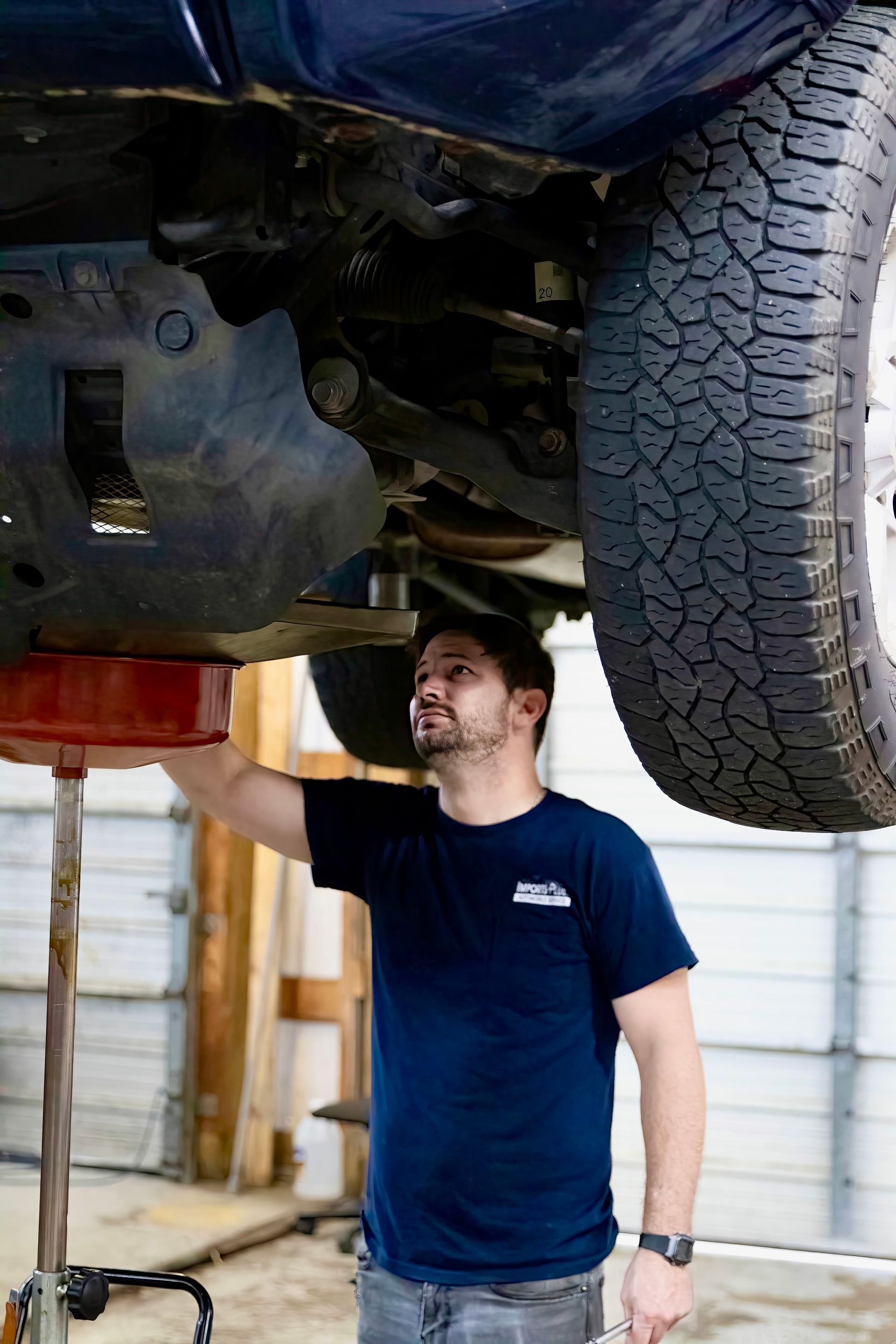 Mechanic Under Vehicle | Imports Plus