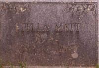 A weathered gray stone grave marker engraved with the names 