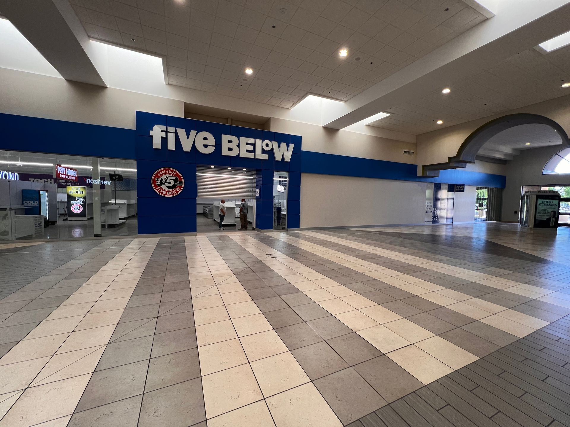 A person painting the exterior of a building from a lift, against a beige and white background.