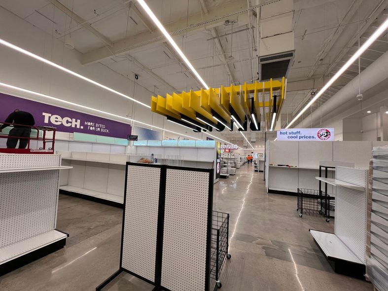 Rope access technician on a white building, cleaning, bright blue sky with clouds.