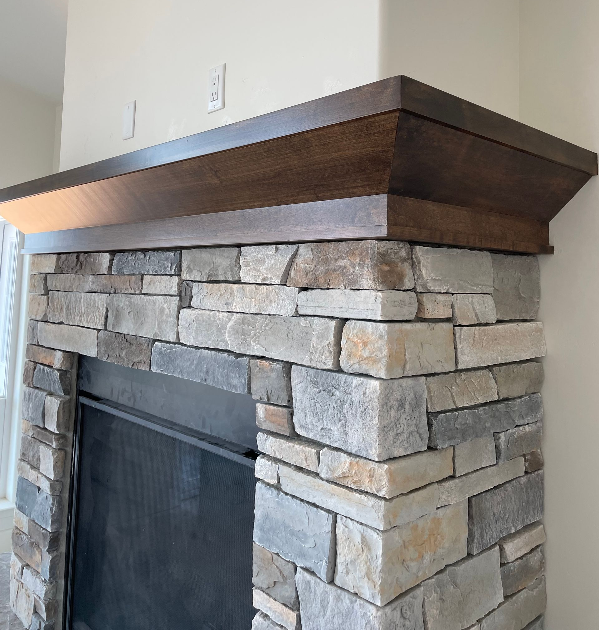 Man in white shirt and gloves smoothing wall plaster with long trowel.