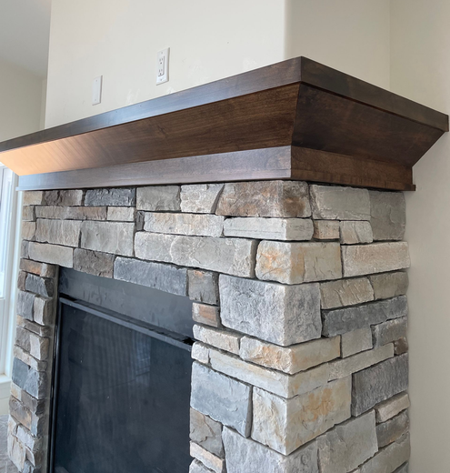 Man in white shirt and gloves smoothing wall plaster with long trowel.