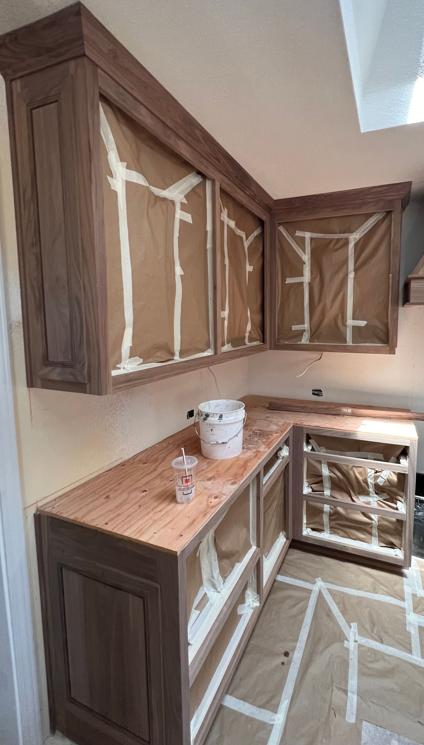 Cozy kitchen with white cabinets, wooden countertops, plants, and stainless steel refrigerator.