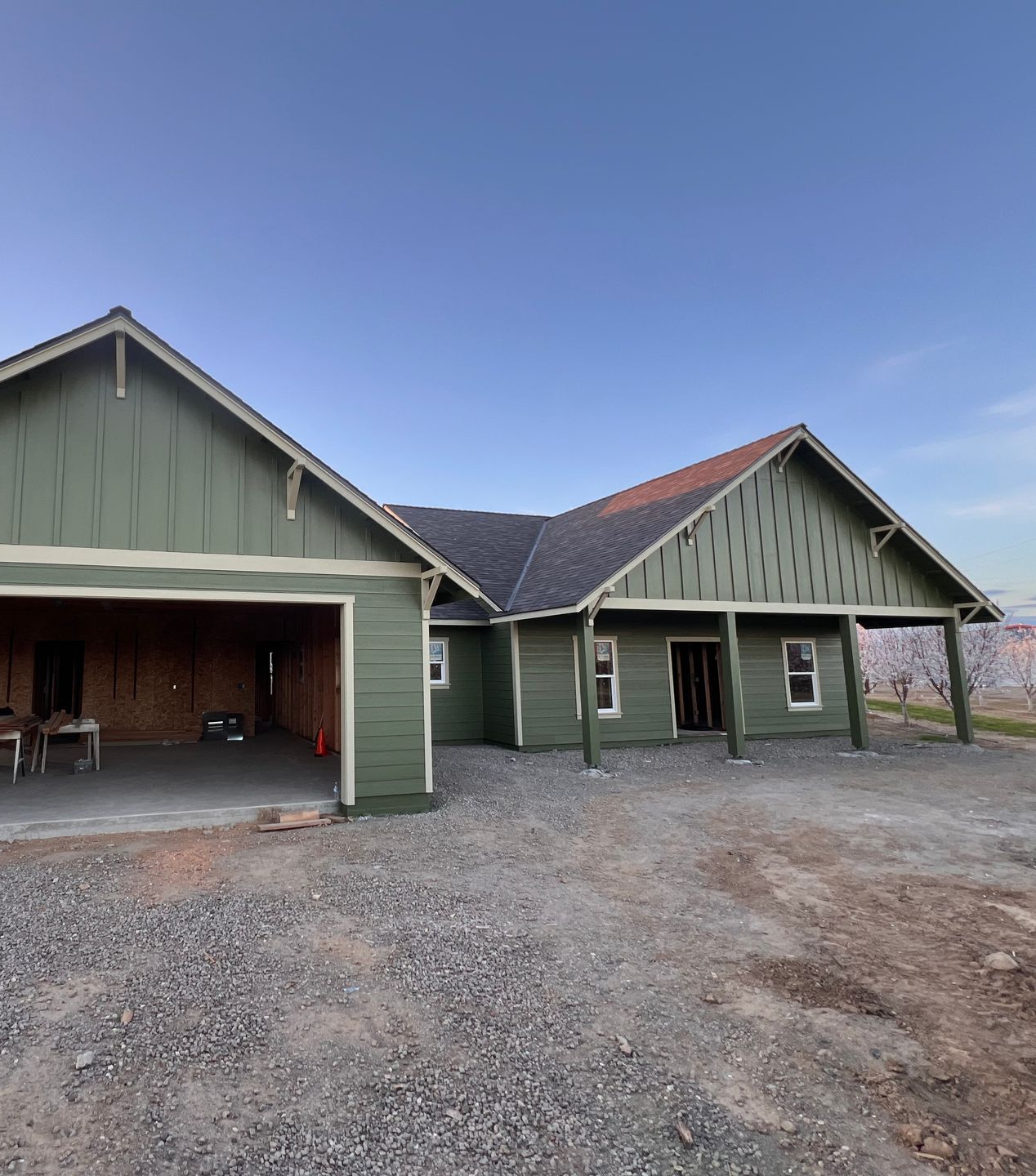 Man painting a turquoise wall around a window, using a roller, with a light tan wall.