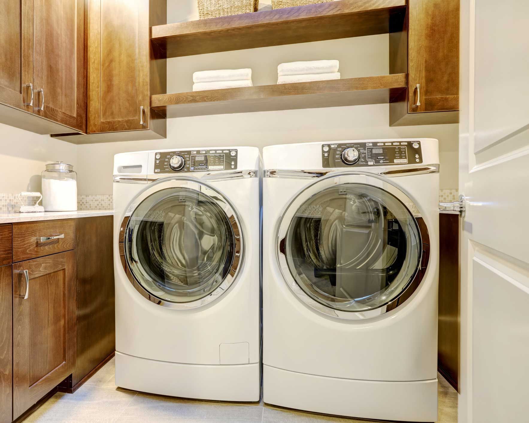 A laundry room with two washing machines and a dryer.