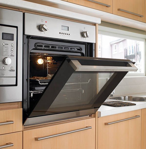 A stainless steel oven with the door open in a kitchen