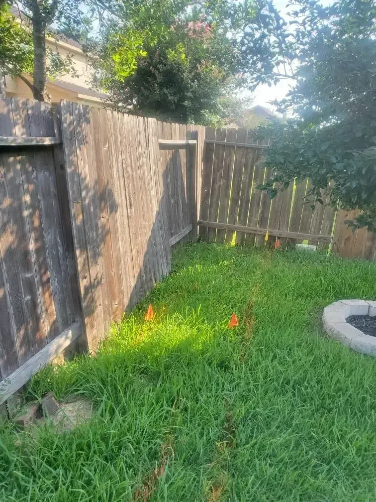 A backyard with a wooden fence and a fire pit.