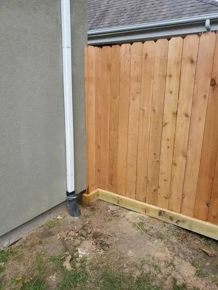 A wooden fence is sitting next to a house.