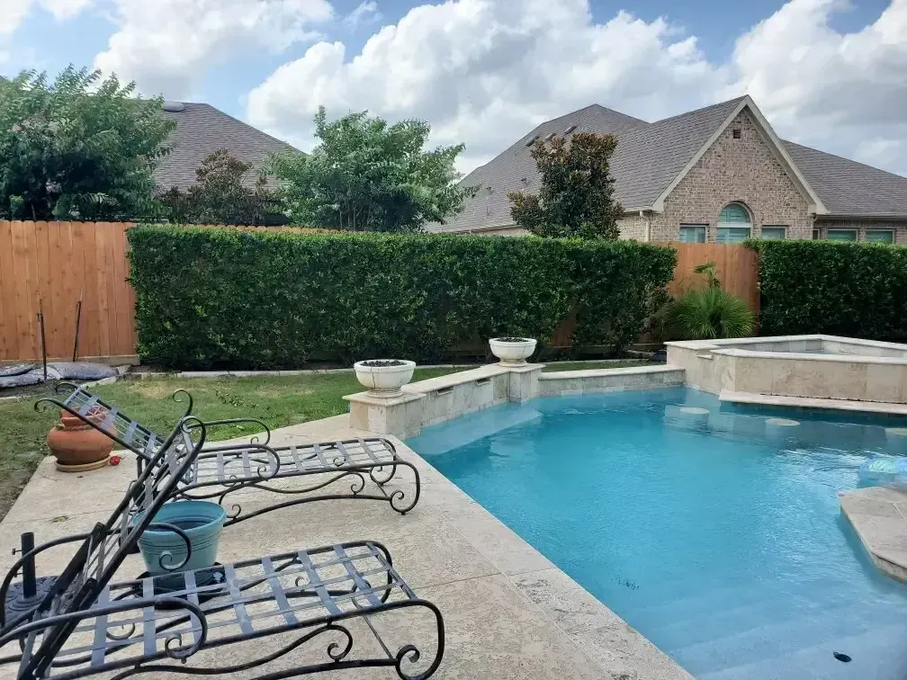 A large swimming pool with a wooden fence surrounding it