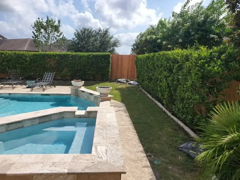 A large swimming pool with a wooden fence surrounding it