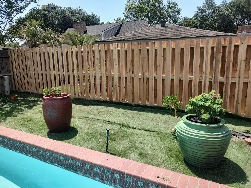 A wooden fence with a gate in the backyard of a house.