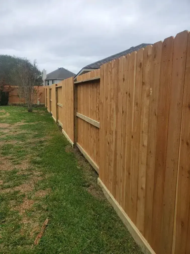 A wooden fence is sitting in the middle of a grassy field.