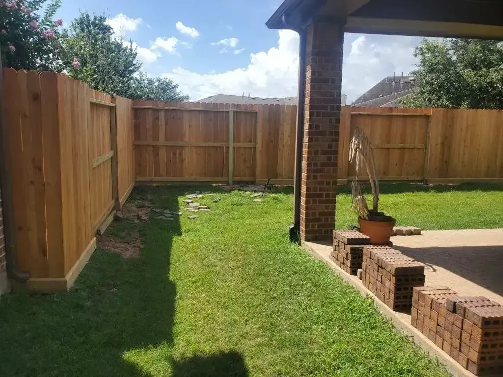There is a wooden fence in the backyard of a house.
