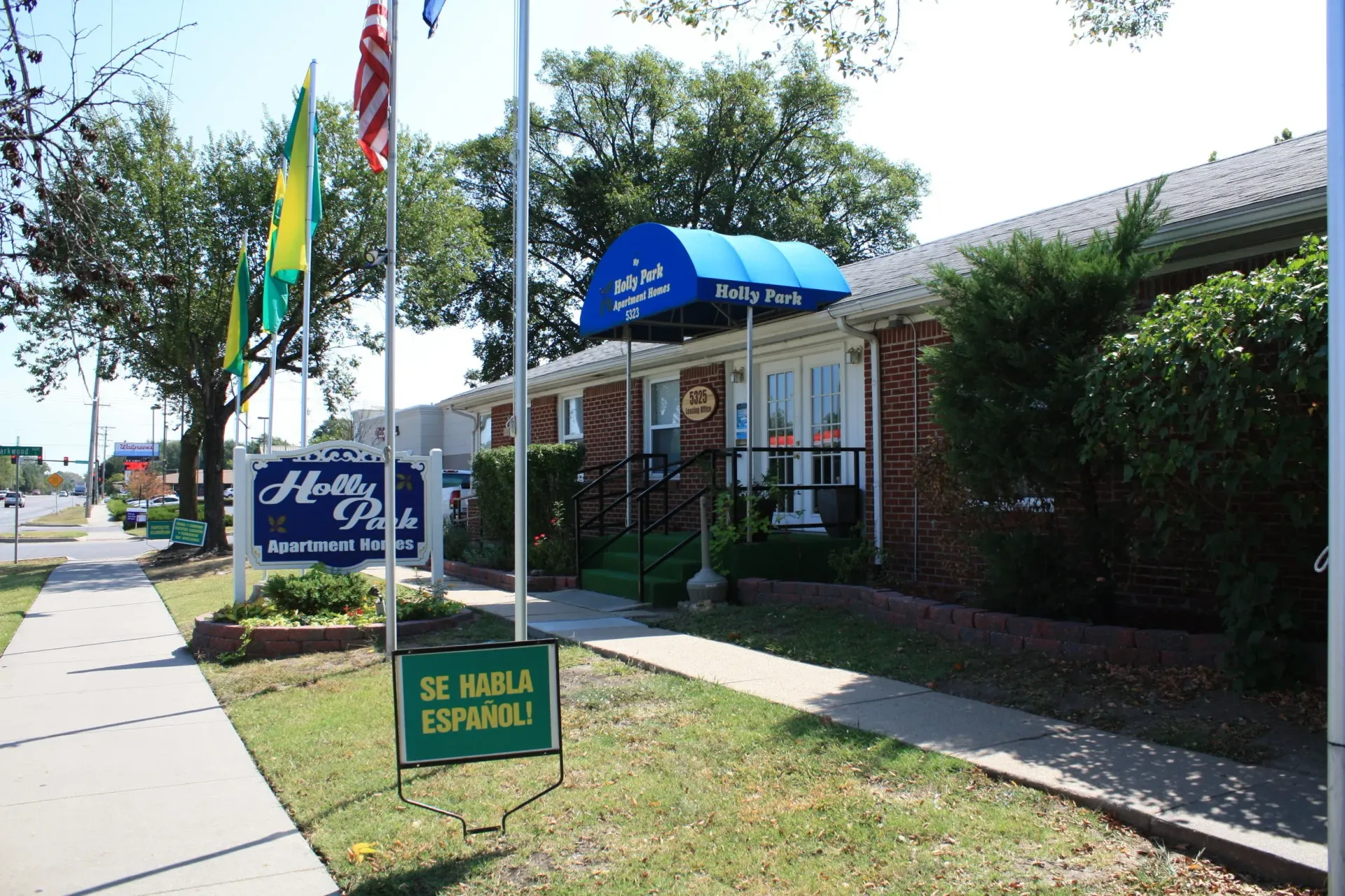 Building with flags and a blue awning reading 
