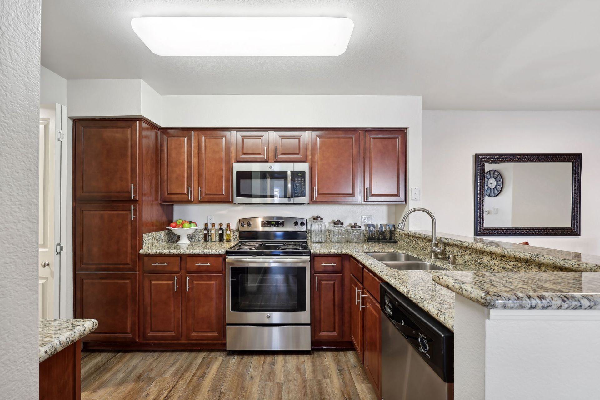 Kitchen with dark wood cabinets, stainless steel appliances, and granite countertops.