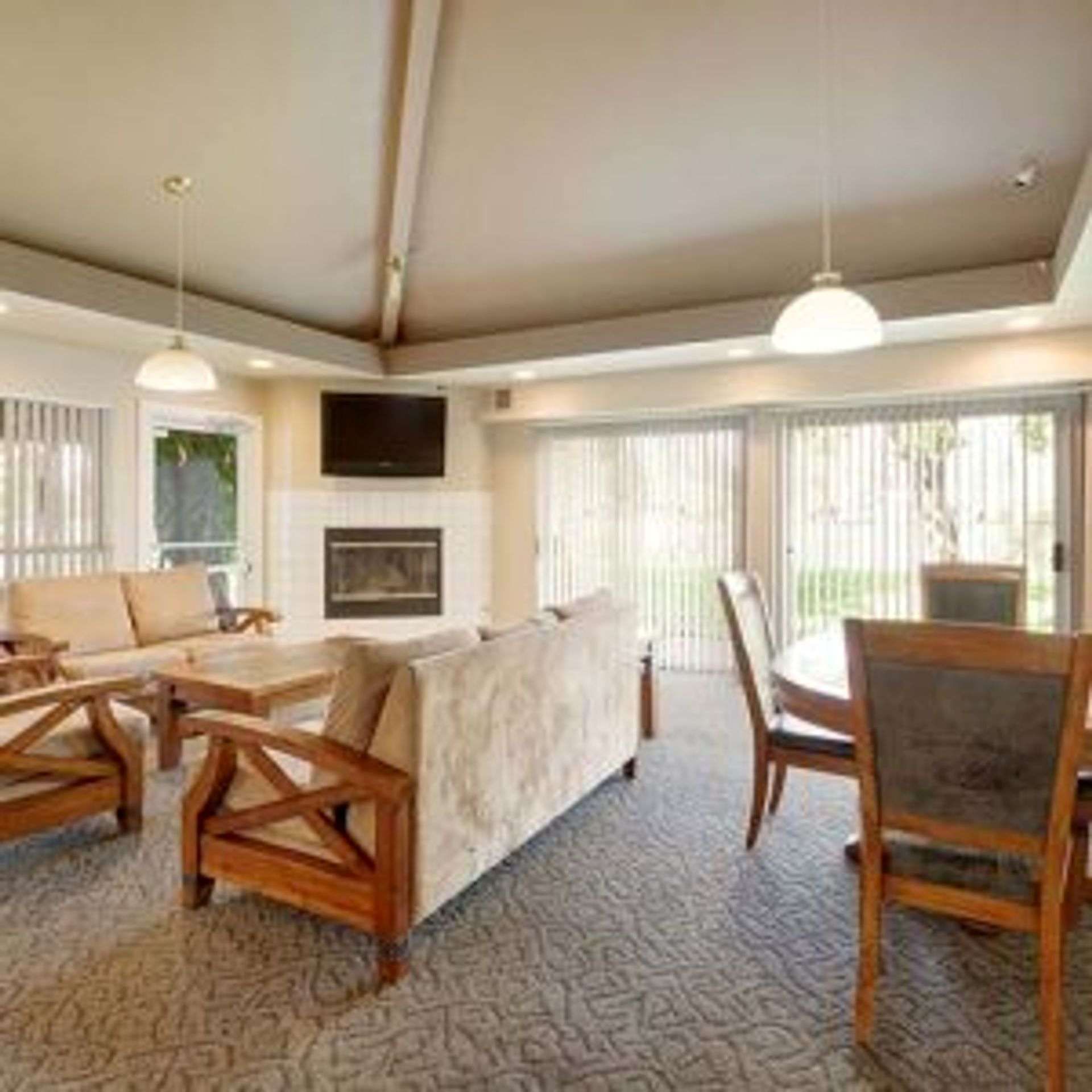 Living room with couches, fireplace, dining table, and sliding glass doors.