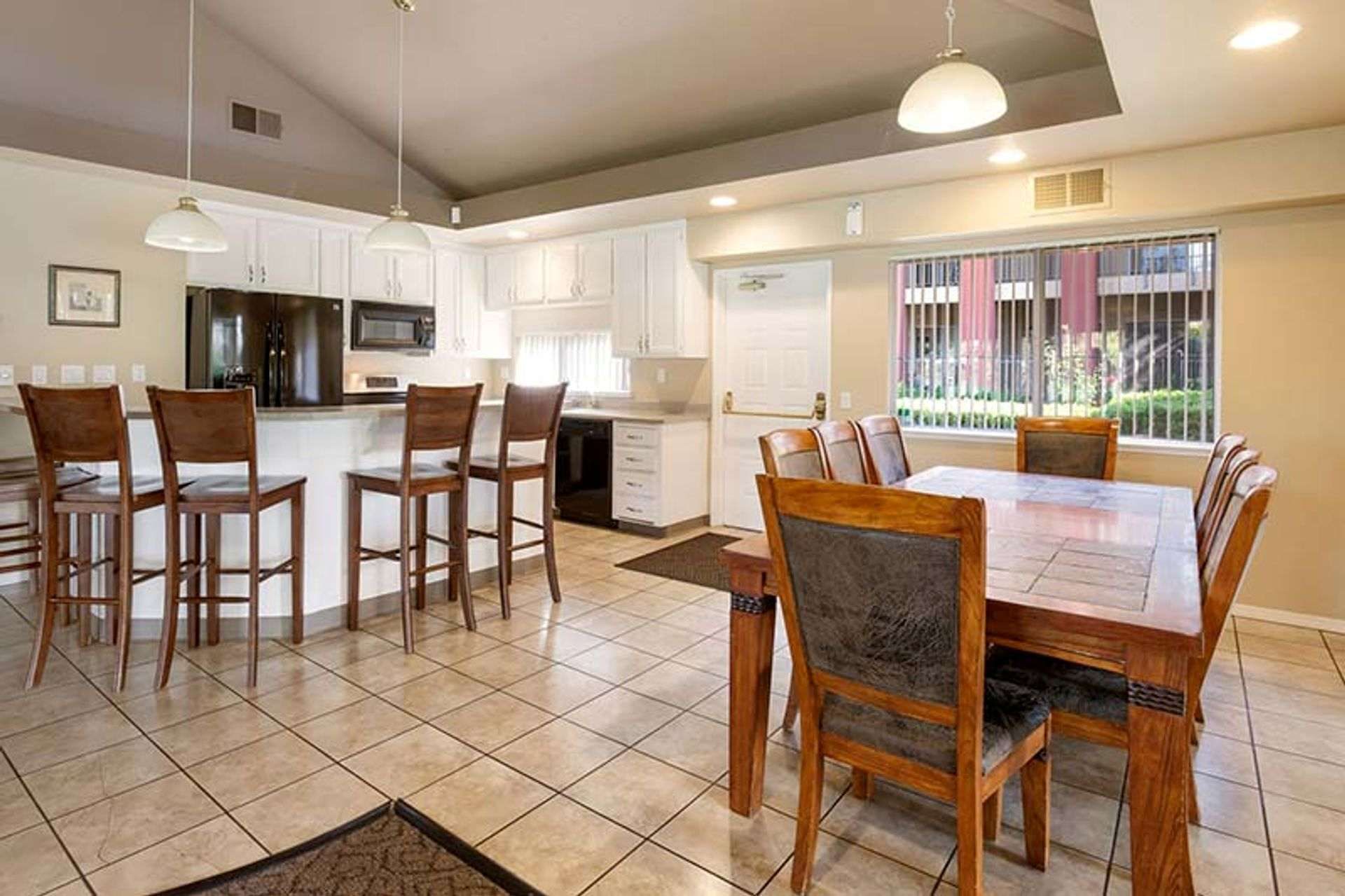 Open-concept kitchen and dining area with a breakfast bar, table, and white cabinetry.