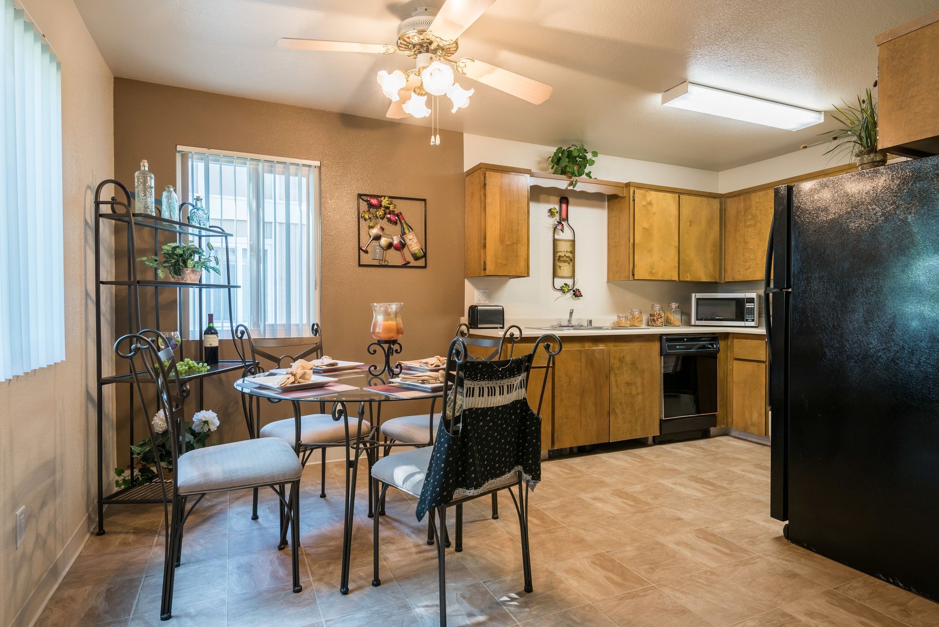 Kitchen and dining area with round table and black appliances.
