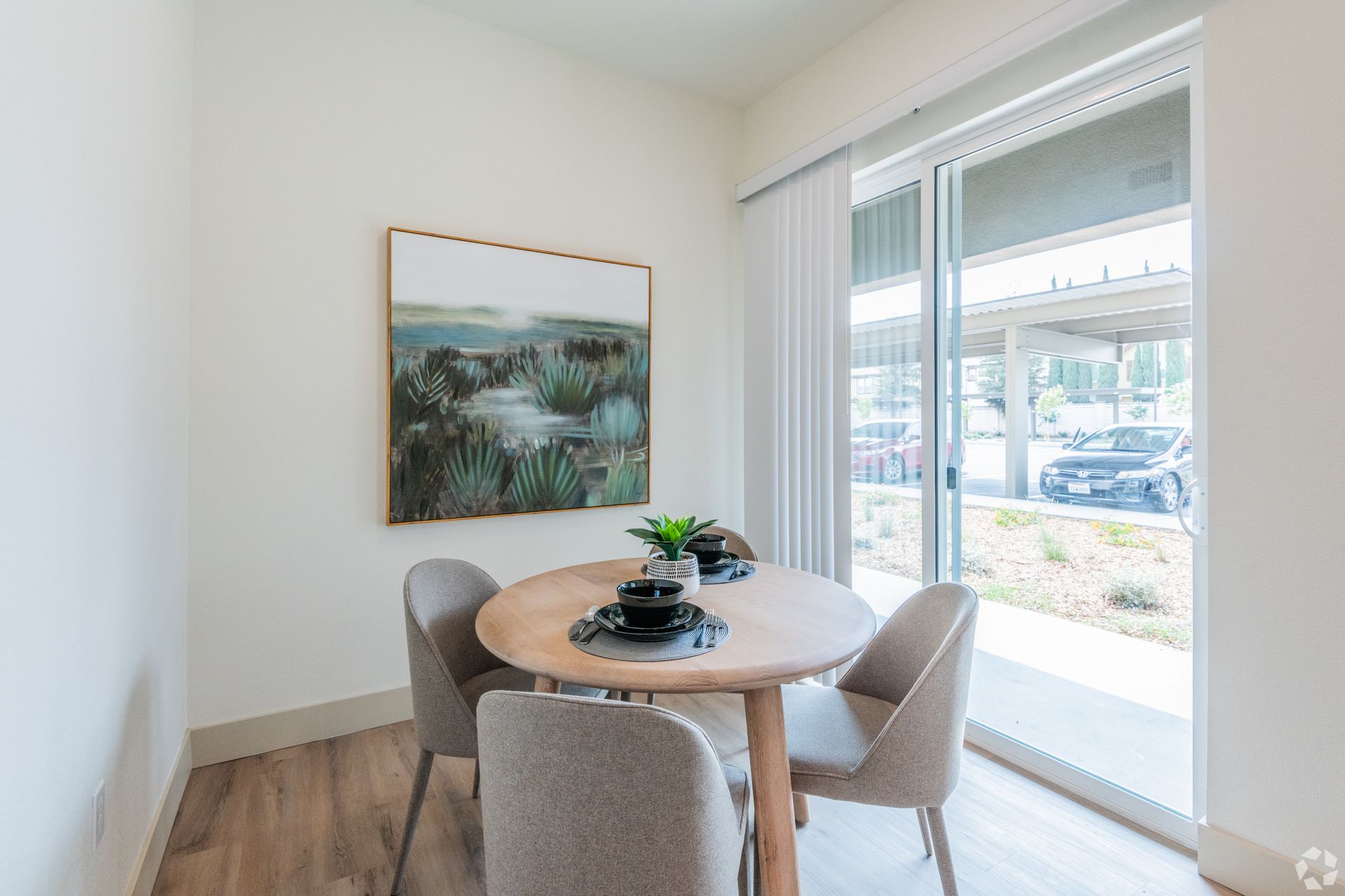 Dining area with a round table, chairs, art, and sliding door to outside.