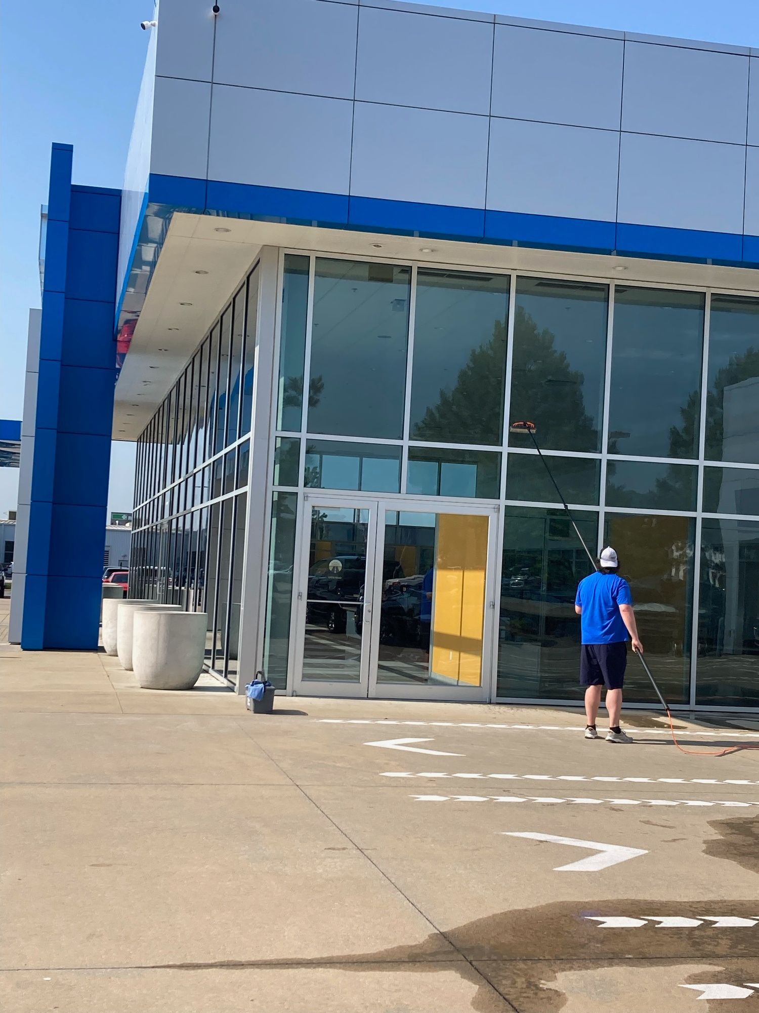 A man is cleaning the outside of a building with a mop