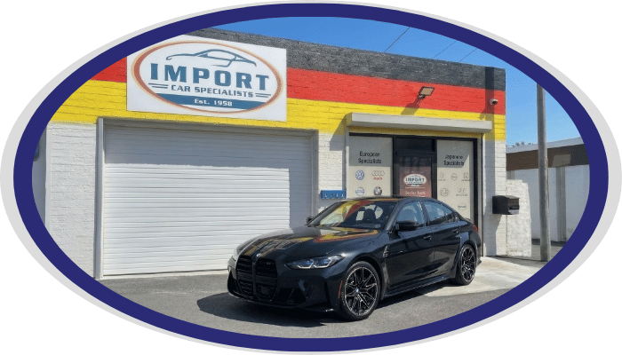 BMW performance sedan in front of Import Car Specialists shop