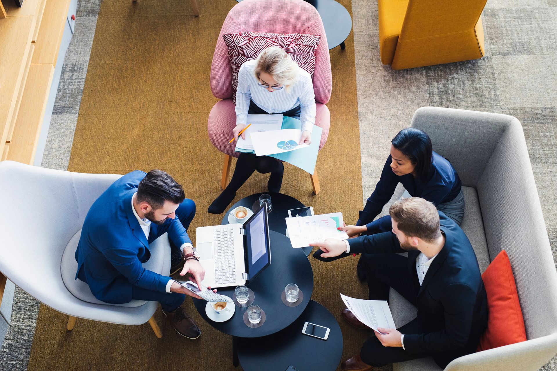 Un grupo de personas está sentada alrededor de una mesa en una sala de estar.
