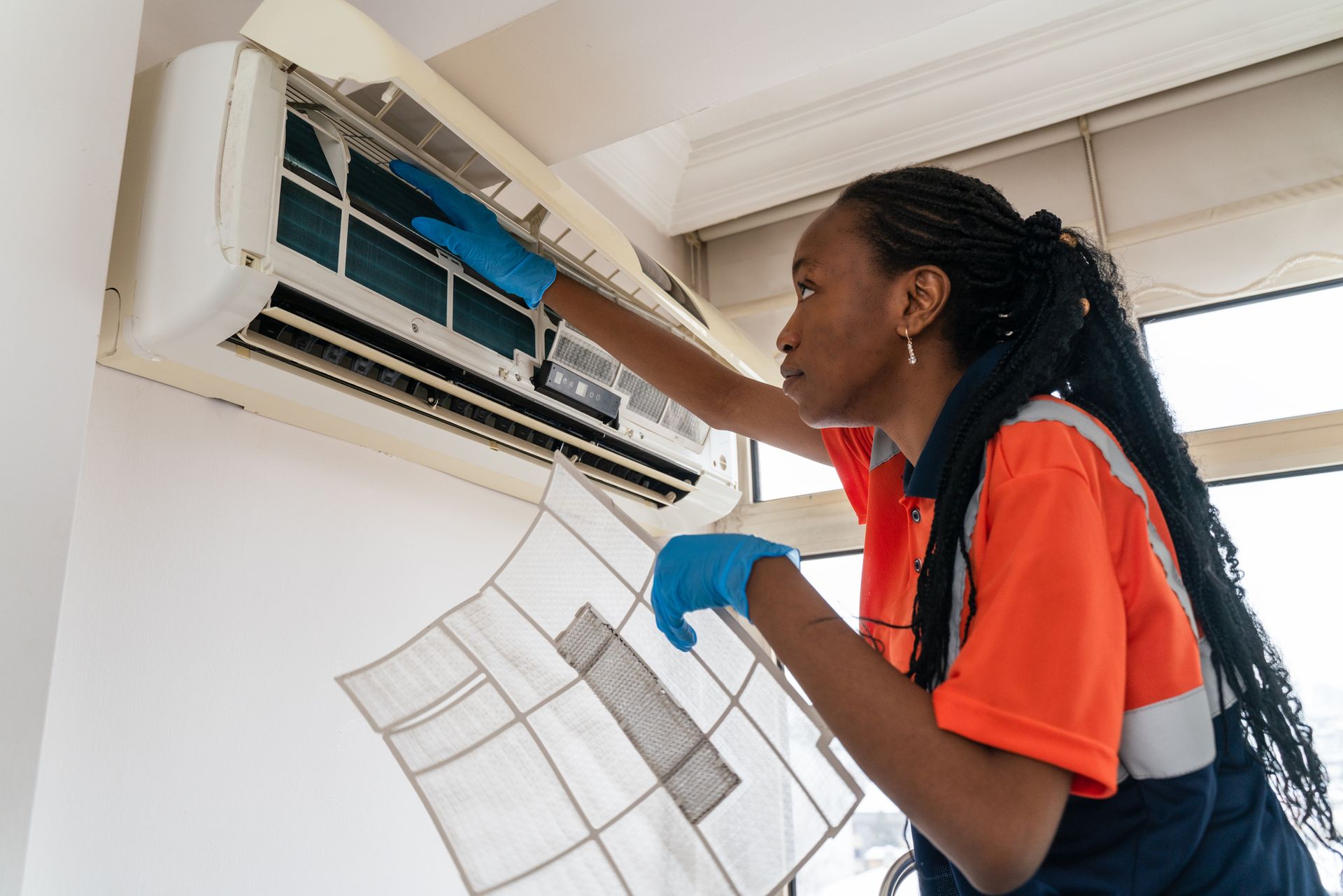 AMS technician checking ductless air conditioner unit.