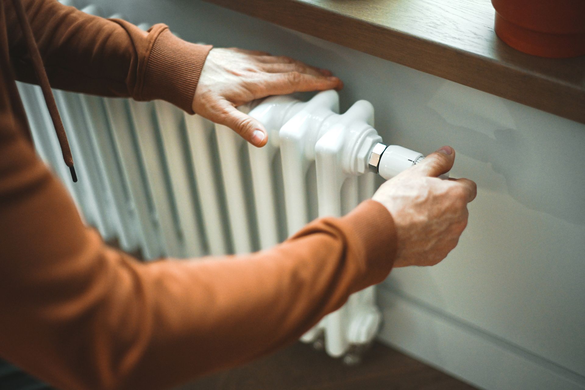 Homeowner inspecting home heating system in Paramus to prepare for winter.