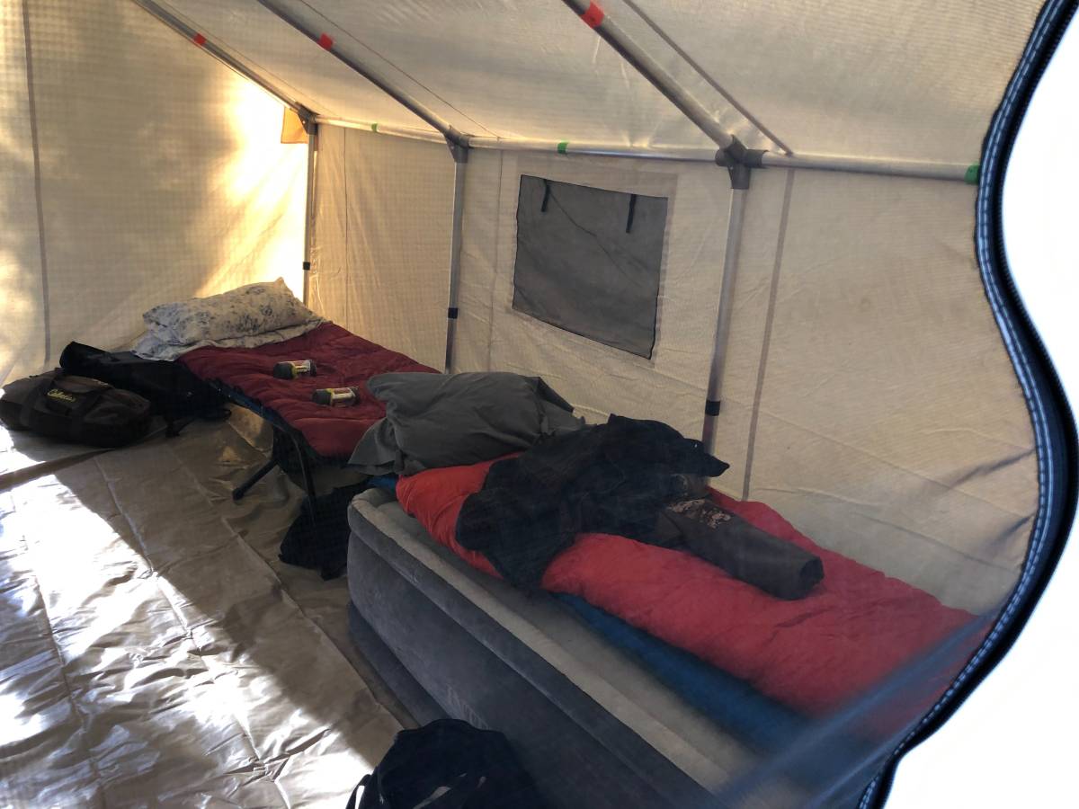 A tent with a bed and sleeping bags inside of it