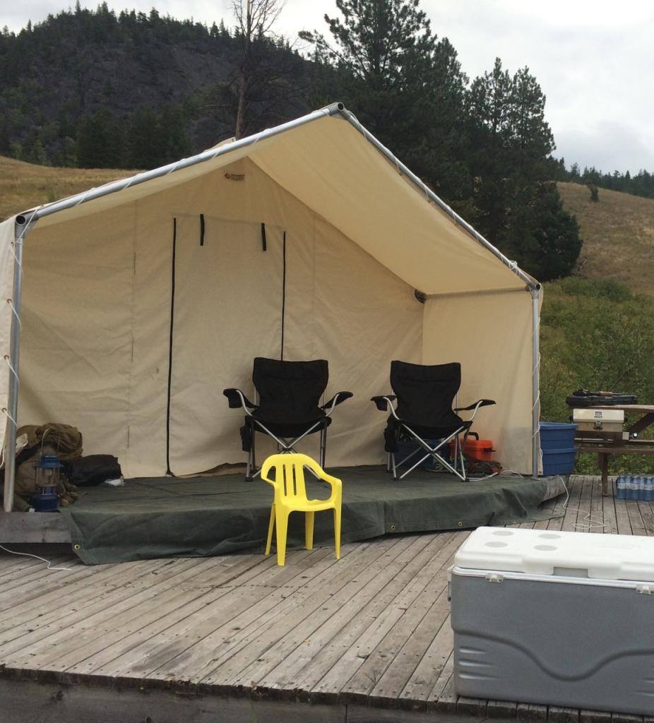 A tent with two chairs and a yellow chair in front of it