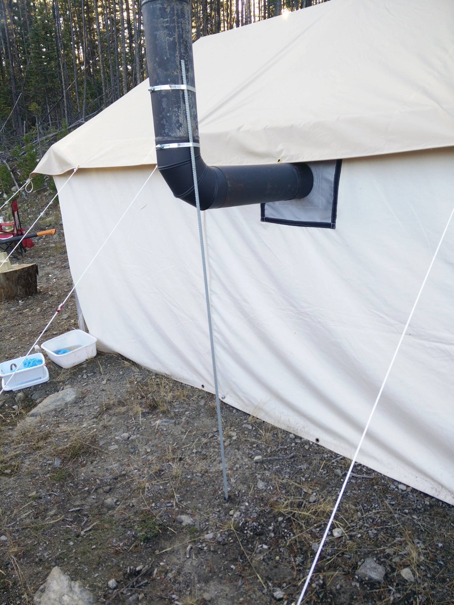A tent with a chimney attached to the side of it