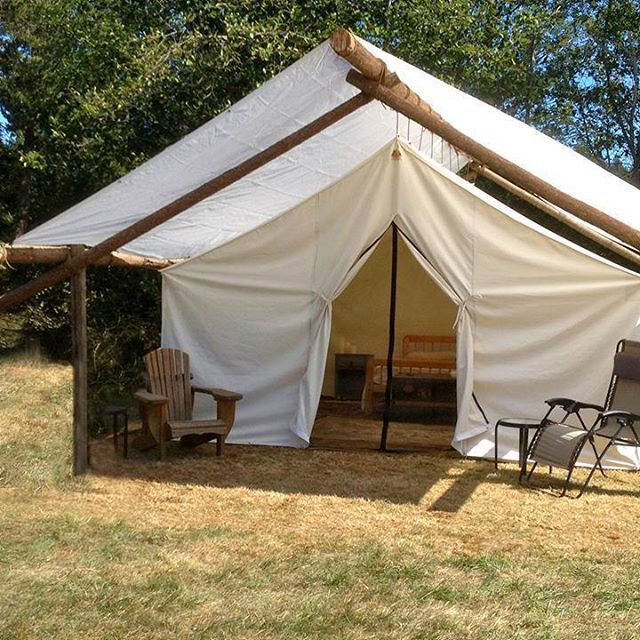 A large white tent is sitting in the middle of a field