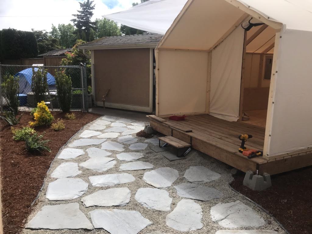 A tent is being built in the backyard of a house