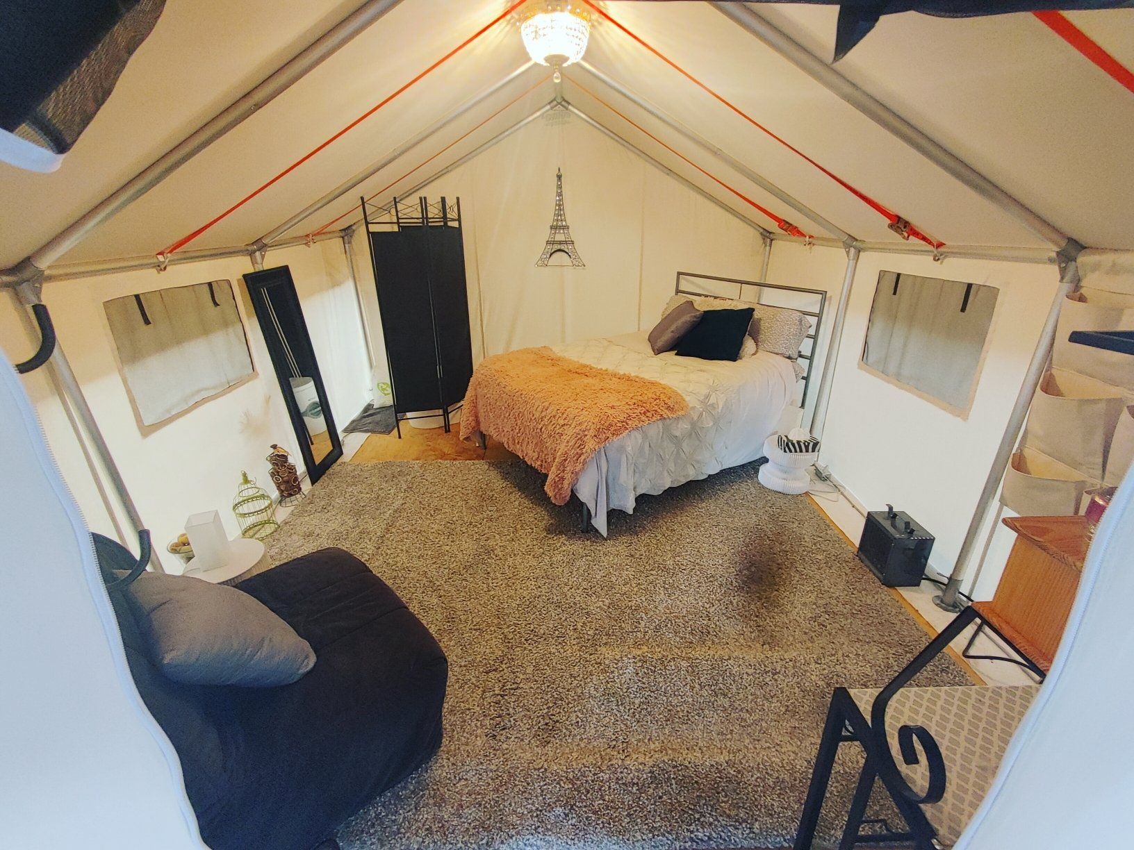 A bedroom in a tent with a bed and a chair