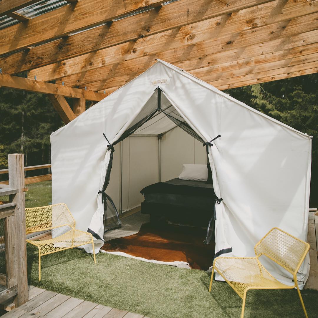 A white tent with a bed inside of it