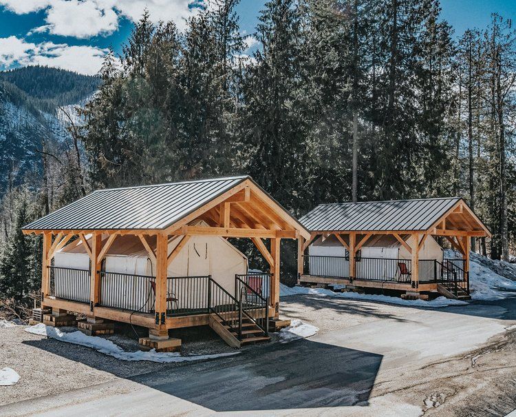 A couple of tents are sitting next to each other in the woods.