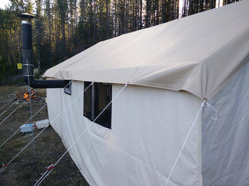 A tent with a chimney attached to the side of it