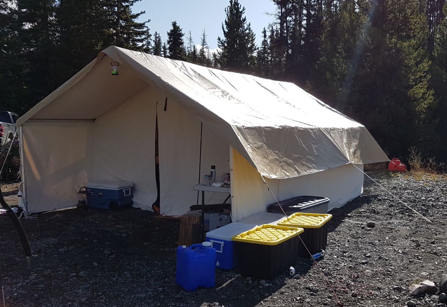 A large white tent sits in the middle of a gravel area